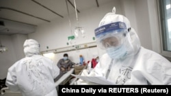 在武汉一家医院,一名身着防护服的医护人员在查看病人的病历。(2020年2月13日)。