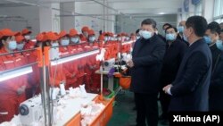 资料照:中共领导人习近平戴着口罩视察陕西安康一家工厂的生产线。(2020年4月21日)