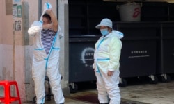 在強制檢測封鎖區內工作的清潔工人需要穿上全套保護衣。(美國之音 湯惠芸拍攝)