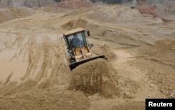 一名中国工人在江西南城县的稀土工地上驾驶推土机。(资料照片)