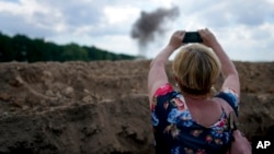 资料照片：一名记者正在拍摄乌克兰扫雷人员清除地雷的场景。（2022年6月9日）