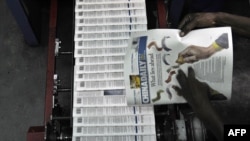 资料照片:肯尼亚首都内罗毕一名技术人员正在检查当地出版的《中国日报》印刷(2013年1月3日)