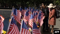 2022年9月10日，在世界贸易中心、五角大楼和宾夕法尼亚州尚克斯维尔袭击事件21周年纪念日的前一天，游客在纽约911纪念馆观看美国国旗。