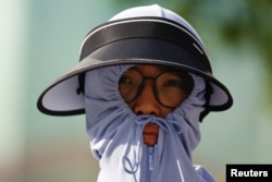 北京街头一名身穿防晒服的行人。(2023年6月30日)