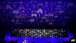 资料照 - 2020年7月27日在韩国首尔举行的纪念联合国部队参加韩战开幕仪式上,当年的联合国老兵的照片投影在一面巨大的墙壁上。