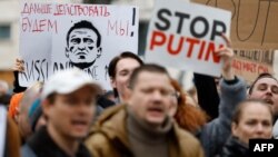 Waandamanaji wakiwa wameshikilia bango linalosomeka "Tutaendelea" mbele ya ubalozi wa Russia mjini Berlin, Februari 18, 2024 wakati wa maombolezo ya kifo cha Alexei Navalny.