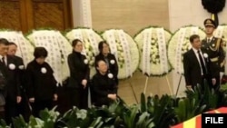 李克强遗体告别现场，其遗孀程虹女士由女儿和亲友陪伴坐在家属席。（网友转发图片）