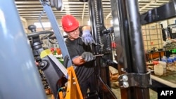 中国山东省青州市的一个铲车工厂的工人在装配铲车。(2023年10月18日)