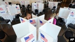 Para pemilih mengisi surat suara mereka untuk pemilihan pendahuluan Michigan di Grosse Pointe Farms, Michigan, Selasa, 27 Februari 2024. (AP/Paul Sancya)