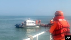 台湾海巡署公布照片显示2024年2月14日海巡人员在金门海域调查一艘中国籍快艇越界进入禁区水域。