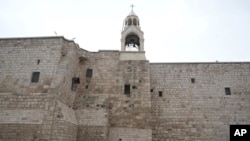 2023 年 12 月 24 日,平安夜,一名牧师走过约旦河西岸城市伯利恒的圣诞教堂,传统上认为这里是耶稣的出生地。