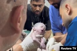Petugas medis menggendong bayi perempuan Palestina yang baru lahir setelah dikeluarkan hidup-hidup dari rahim ibunya yang terbunuh dalam pemboman Israel di Rafah di Jalur Gaza selatan, Sabtu malam (20/4).