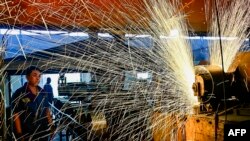 资料照片:中国山东省青州市一个汽车轮辋工厂的工人正在生产线上工作。(2024年6月17日)