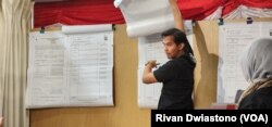 Petugas KPPSLN memperhatikan pengumuman hasil penghitungan suara sebelum dicatat ke data rincian perolehan suara. (Foto: VOA/Rivan Dwiastono)