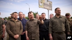 据乌克兰总统新闻办公室公布的照片,乌克兰总统泽连斯基(左一)2023年6月8日视察了遭洪水侵袭的赫尔松地区。