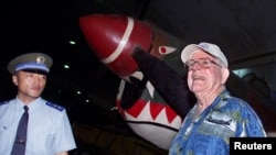 曾经在二战期间驾驶飞机帮助中国抗日的美国飞虎队飞行员Eriksen Shilling与一名中国人民解放军空军飞行员在北京郊区的中国航空博物馆里站在一架展出的Curtis P-14飞机模型前。(2001年9月6日)