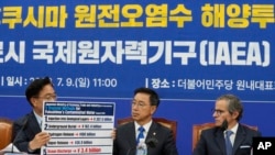 2023年7月9日，在韩国首尔举行的一次会议上，议员禹元植展示了福岛污染水的拟议处理方法，议员魏圣坤和国际原子能机构总干事拉斐尔·格罗西（右）在一旁观看。