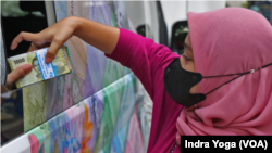 Setelah menyelesaikan tertib administrasi dan proses penukaran uang, warga dapat menerima pecahan uang kecil dalam bentuk Rp1.000, 2.000, 5.000, 1.000 hingga 20.000. (Foto: VOA/Indra Yoga)