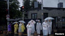 2023年7月30日,北京地区暴雨倾盆。游客们身穿雨衣,打着雨伞,游览北京雨景。北京气象部门已经发出北京可能有创纪录降雨的警报。