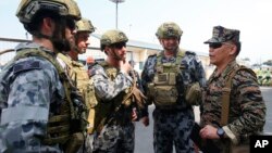 资料照:菲律宾海军发言人罗伊‧文森特‧特立尼达准将(Commodore Roy Vincent Trinidad 右)与澳大利亚皇家海军士兵交谈。(2017年10月10日)