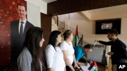 Seorang pria Suriah memasukkan surat suaranya di kotak penitipan suara di sebuah TPS di Damaskus, Suriah, Senin, 15 Juli 2024, untuk memilih anggota parlemen baru. (Omar Sanadiki/AP)