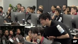 在ispace提供的视频中的图像中,东京的飞行控制人员在2023年4月26日早些时候尝试在月球表面着陆后,等待该公司的“白兔”航天器的信号。(美联社照片)