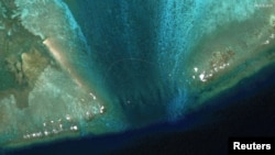 卫星图像显示在南中国海有主权争议的斯卡伯勒浅滩(中国称黄岩岛)潟湖入口处被安放了一道新的浮动屏障。(2024年2月24日)