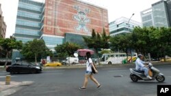 资料照:台北一名女子走过旺旺中时媒体集团总部大厦。(非当事媒体) (2012年7月26日)