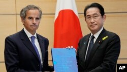 라파엘 그로시(왼쪽) 국제원자력기구(IAEA) 사무총장이 4일 일본 도쿄에서 기시다 후미오 총리에게 후쿠시마 제1원자력발전소 오염처리수 방류계획을 평가한 IAEA 최종 보고서를 전달하고 있다.