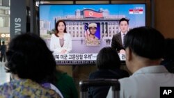 资料照片:在韩国首尔的一座火车站,人们观看有关美军士兵特拉维斯·金越界进入朝鲜的电视新闻。(2023年7月22日)