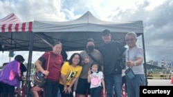 东台湾花莲市区天王星大楼的原9楼住户林天赐(右一)、林太太(左一)、儿子(左三)、女儿(左二)和孙女(中)一家人在救助点前,以及自台北来访的乾儿子(右二)。(照片来源:林天赐提供)