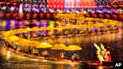 中共官媒新华社发布照片显示，游客们在湖北省宣恩县乘坐竹筏参加迎新春灯会游湖活动。（2024年2月11日）