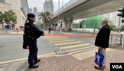 押送黎智英到西九龙裁判法院应讯的囚车,即将驶入法院大楼入口时,大批警员在附近的行人过口处拉起封锁线禁止行人横过马路 (美国之音/汤惠芸)