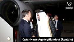 法国总统马克龙在多哈机场受到卡塔尔外交国务大臣穆罕默德·胡莱菲的迎接。(2023年12月2日)