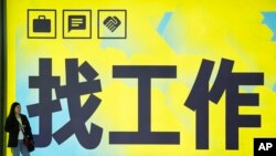 一名女子站在北京一个地铁站张贴的“找工作”的广告牌前。(2024年7月2日)