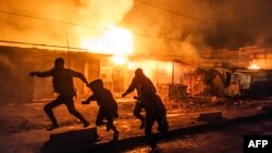 Watu wakikimbilia kuokoa maisha yao kufuatia mfululizo wa milipuko iliyosababisha moto katika eneo la Embakasi Nairobi Februari 2, 2024. Picha na LUIS TATO / AFP.