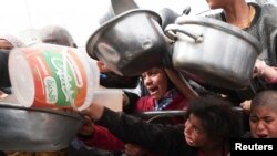 加沙地带拉法地区的巴勒斯坦儿童等待领取慈善机构分发的食品。(2024年2月13日)