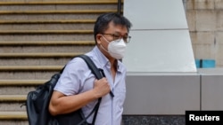 被香港当局通缉的前香港公民党执委(党务发展)、香港立法会法律界功能界别议员郭荣铿的哥哥郭荣臻离开警局。(2023年7月20日)