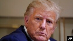 资料照片: 2023年3月25日,在德克萨斯州韦科的韦科地区机场举行的竞选集会后,前总统唐纳德·特朗普在飞机上与记者交谈时在倾听。