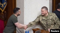 资料照片:乌克兰总统泽连斯基与武装部队总司令扎卢日内将军在议会的一次会议期间握手。(2022年7月28日)