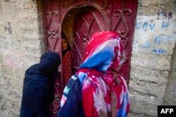 Seorang polisi Pakistan menginterogasi seorang pengungsi Afghanistan dalam operasi penindakan imigran ilegal di pinggiran Karachi, Pakistan, 17 November 2023. (Foto: Asif Hassan/AFP)