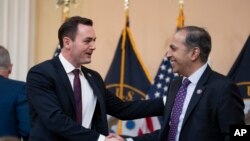 资料照片：众议院美国与中国共产党战略竞争特设委员会主席、共和党众议员加拉格尔与该委员资深成员、民主党众议员克里希纳莫提在举行听证会前握手。(2023年2月28日)