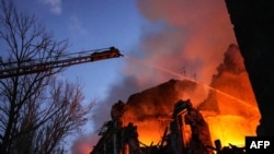 俄罗斯导弹袭击乌克兰港口城市尼古拉耶夫,乌克兰救援人员正在扑救被炸民房的大火。(2023年7月20日)