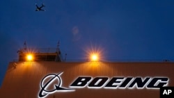 资料照片:一架飞机飞过西雅图波音机场波音公司新扩建的737交付中心。(2015年10月19日)
