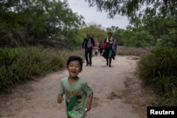 一名5岁来自中国的男童和他的家人渡过美墨边境的格兰德河走在美国德克萨斯州的道路上。(2023年4月5日)