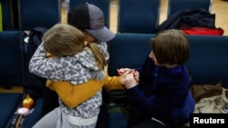 从白俄罗斯边境回到乌克兰的乌克兰女童和哥哥在基辅与家人团聚。(2023年4月8日)