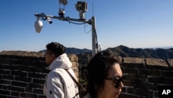 北京长城上安装的监控摄像头与游客。(2023年10月20日)