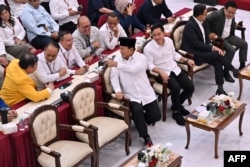 Presiden terpilih Prabowo Subianto berbincang dengan sejumlah politisi dari koalisi partai yang mendukungnya saat acara penetapan hasil pilpres 2024 di Komisi Pemilihan Umum (KPU) di Jakarta, 24 April 2024. (Foto: Adek Berry/AFP)