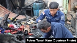 Polisi saat melakukan olah tempat kejadian perkara kasus kebakaran rumah jurnalis di Kabanjahe, Kabupaten Karo, Provinsi Sumatra Utara, 27 Juni 2024. (Foto: Polres Tanah Karo)
