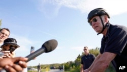 拜登总统2023年5月14日在特拉华州里霍博斯海滩的戈登斯池塘州立公园骑自行车时与记者讲话。(美联社照片)